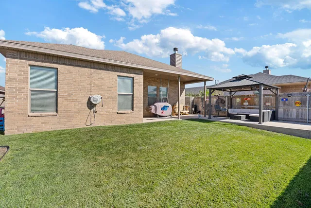 a view of a house with a backyard and a patio