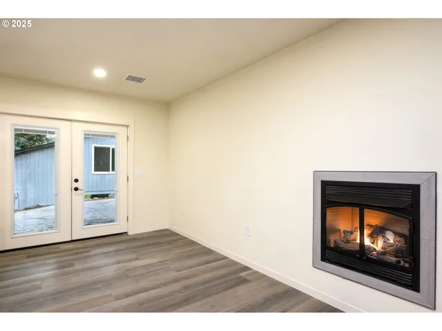 a view of empty room with kitchen and window