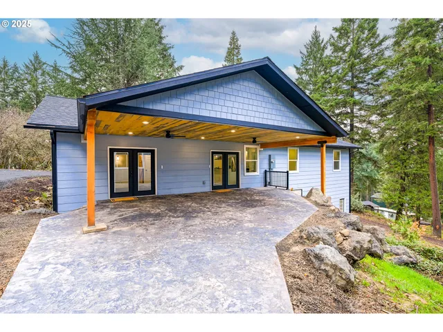 a view of a house with backyard and trees