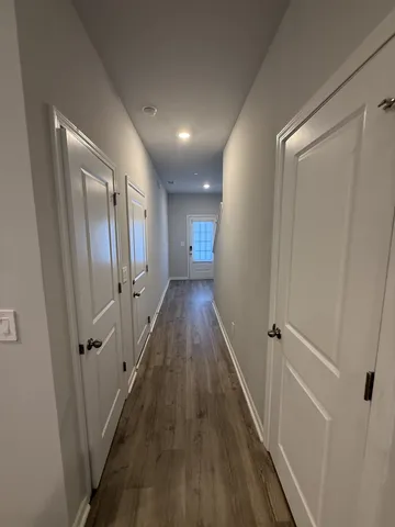 a view of a hallway with wooden floor and staircase