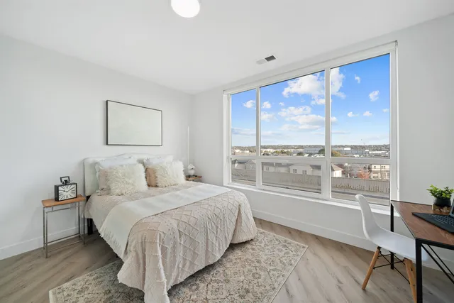 a bedroom with a large window and a bed