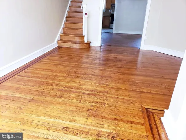 a view of an empty room with wooden floor