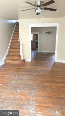 a view of a hallway with wooden floor and staircase