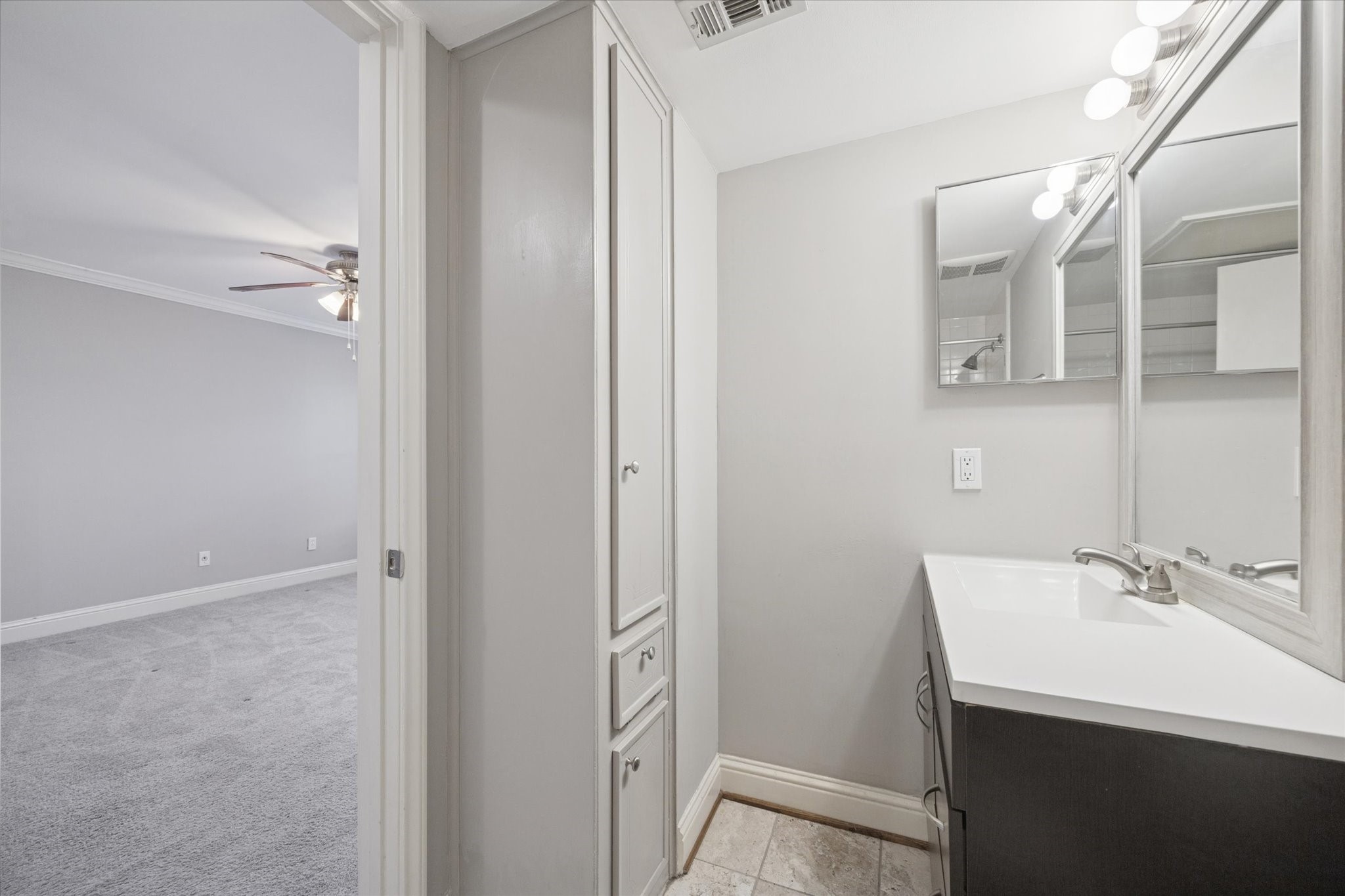 1531 Marshall Street, Unit 1 Houston, TX 77006 - Photo 13 of 19 The updated vanity area features painted cabinetry, modern lighting, convenient linen storage, and a separate water closet with a tiled tub and shower enclosure, all wrapped in a clean, bright aesthetic that makes daily routines feel effortless.