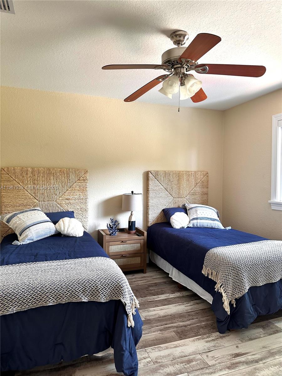 24 Tarpon Avenue Key Largo, FL 33037 - Photo 19 of 22 a bedroom with a bed and wooden floor