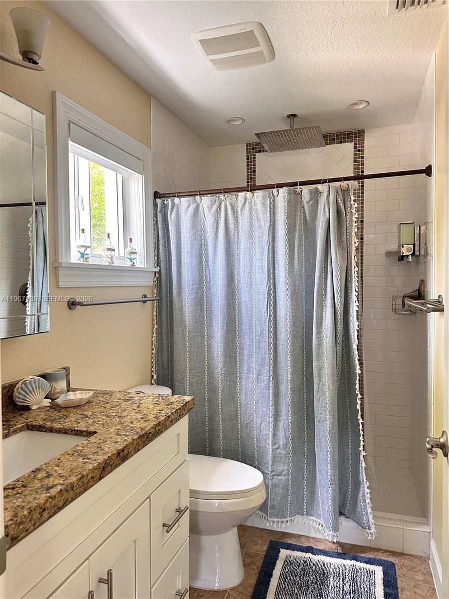 24 Tarpon Avenue Key Largo, FL 33037 - Photo 9 of 22 a bathroom with a granite countertop sink toilet and shower