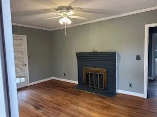 a living room with a fireplace and wooden floor