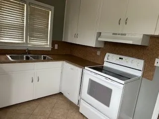 a kitchen with white cabinets and white appliances