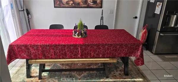 a bed sitting in a bedroom next to a window with potted plants on a table chair