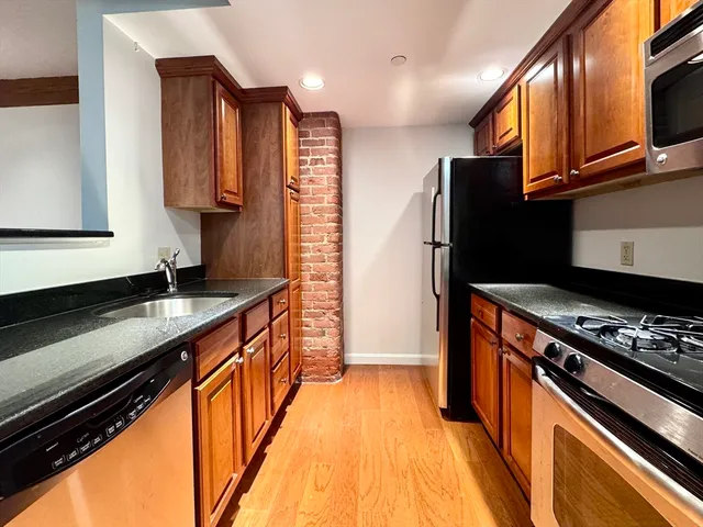 a kitchen with stainless steel appliances a sink dishwasher stove and refrigerator