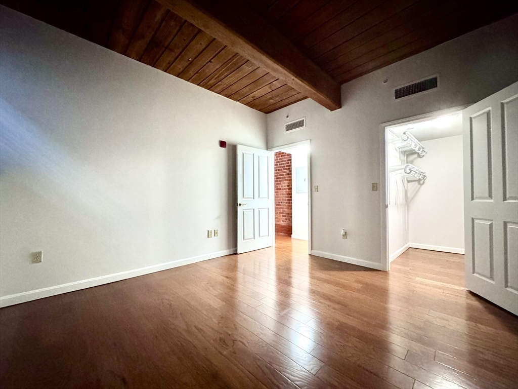4 Bishop Street, Unit G11 Framingham, MA 01702 - Photo 14 of 24 a view of an empty room with wooden floor and a window