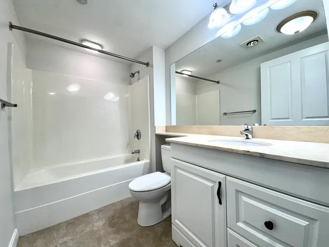 a bathroom with a sink a toilet and a large mirror