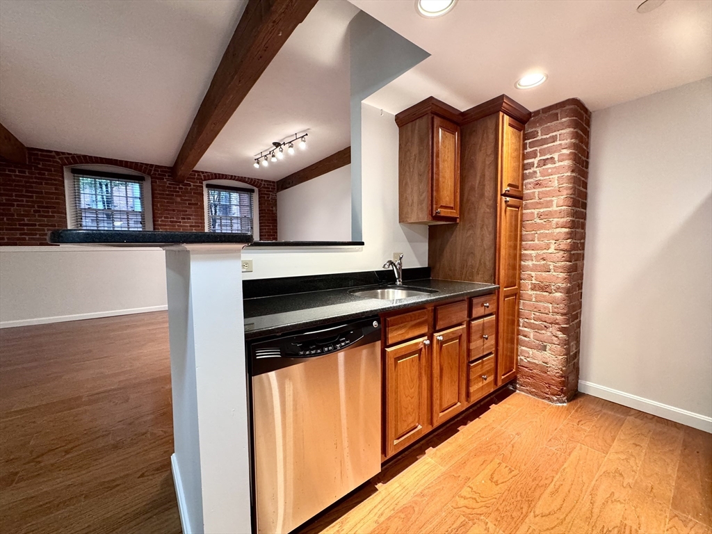 4 Bishop Street, Unit G11 Framingham, MA 01702 - Photo 5 of 24 a kitchen with stainless steel appliances granite countertop a stove a sink and a microwave