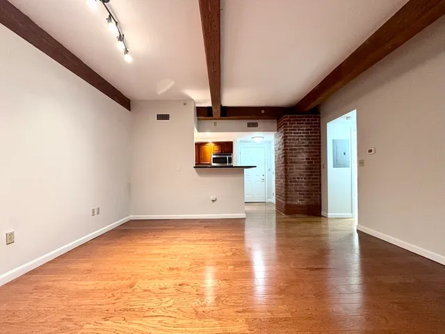 an empty room with wooden floor and a window