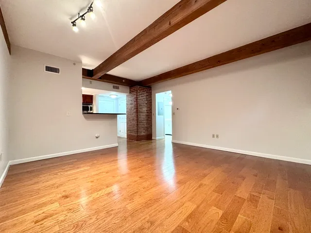 a view of a livingroom with wooden floor and a window