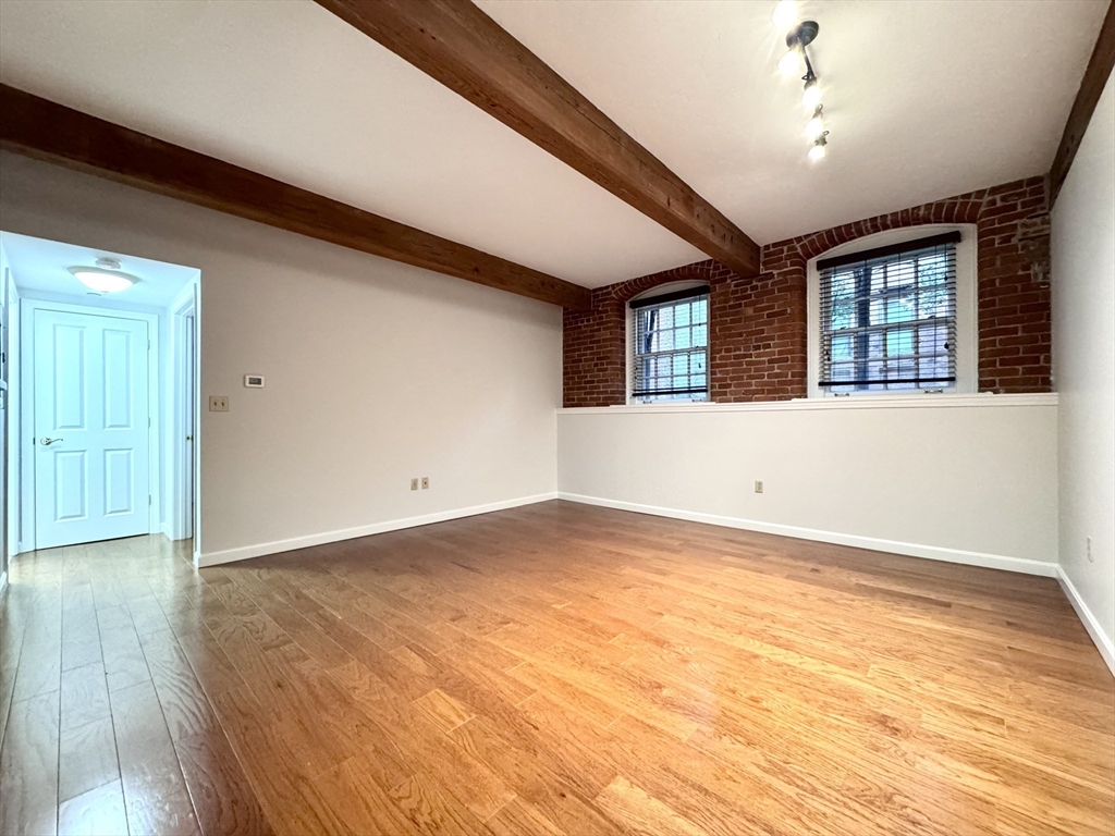 4 Bishop Street, Unit G11 Framingham, MA 01702 - Photo 10 of 24 a view of an empty room with wooden floor and a window