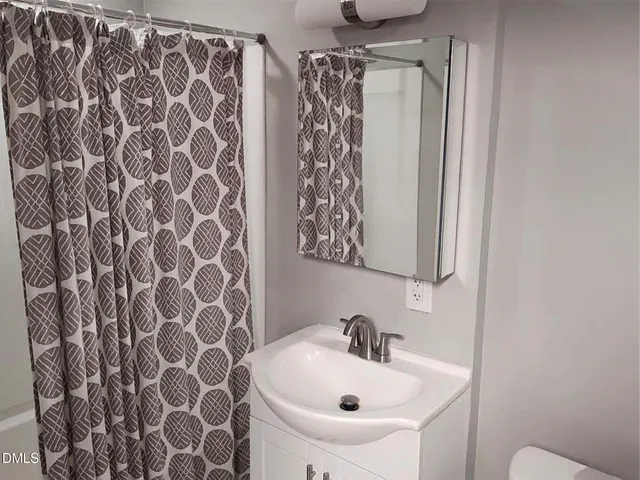 a bathroom with a sink and mirror with toilet