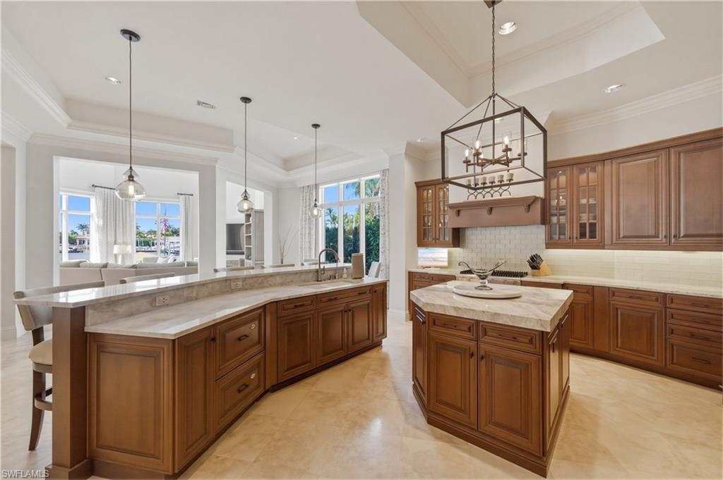 361 Pirates Bight Naples, FL 34103 - Photo 13 of 45 a kitchen with stainless steel appliances granite countertop a sink a stove and a wooden floors