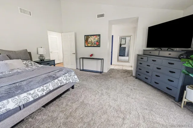 a bedroom with a bed and a flat screen tv