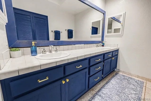 a bathroom with a double vanity sink and large mirror
