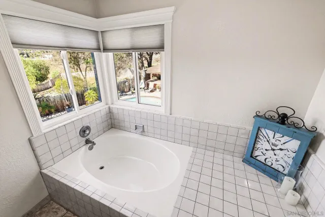 a bathroom with a tub a window and a shower