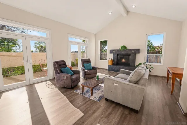a living room with fireplace furniture and a large window