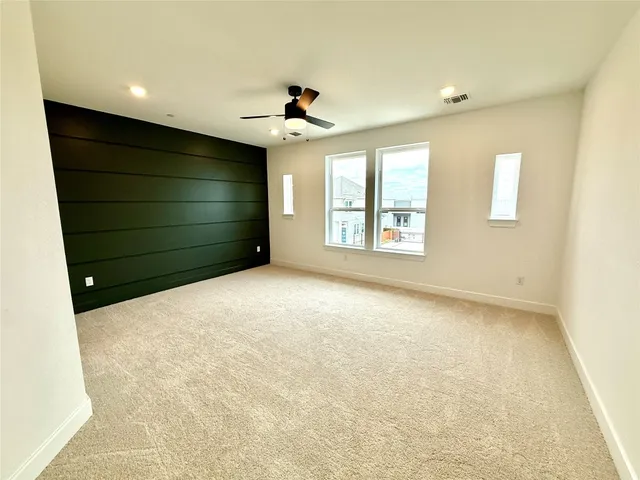 an empty room with windows and ceiling fan