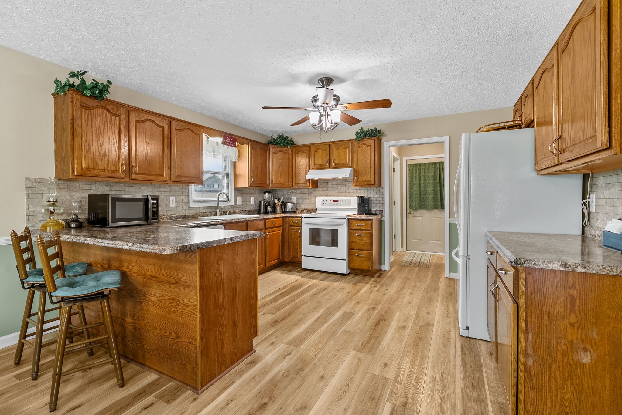1230 Bark Ridge Circle Hopkinsville, KY 42240 - Photo 10 of 38 a kitchen with granite countertop wooden floors stainless steel appliances a sink and cabinets