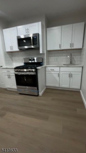 178 3rd Street, Unit 4 Elizabeth Port, NJ 07206 - Photo 2 of 6 a kitchen with a stove and white cabinets