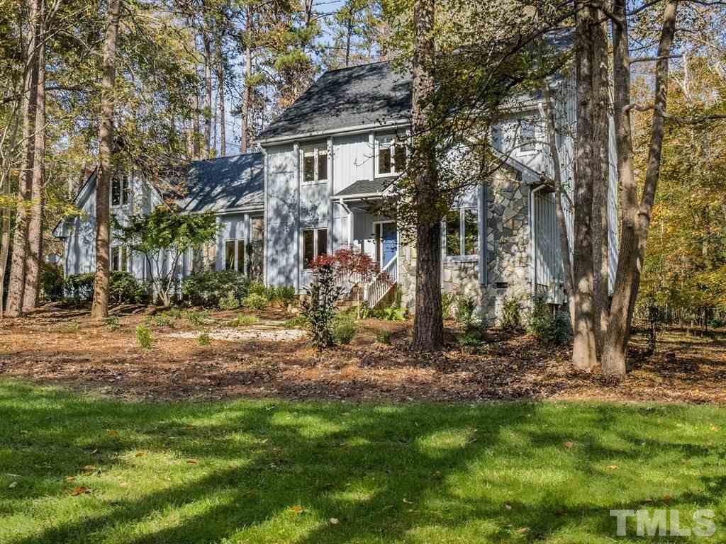 Set between hardwood trees and mature landcaping, this stone and wood home, with a covered entry sits on a private 1.17 acre lot.