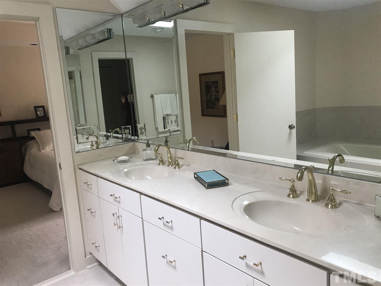10000 Grafton Road Raleigh, NC 27615 - Photo 17 of 25 Updated master bathroom with double vanities, new faucets, updated lighting and large mirror. Skylight in center of bathroom allows natural light to filter in.