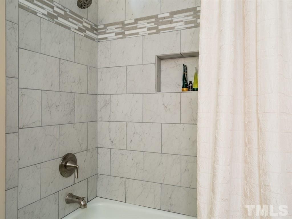 10000 Grafton Road Raleigh, NC 27615 - Photo 19 of 25 Refurbished bathroom with newly tiled shower and flooring and brushed nickel finishing touches.