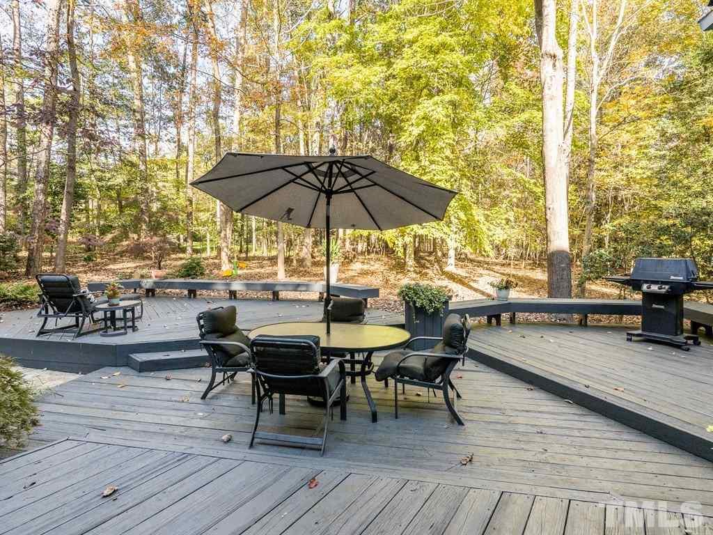 10000 Grafton Road Raleigh, NC 27615 - Photo 4 of 25 Large multi tiered decking, recently sanded and restained. The deck offers built in planters and seating and is surrounded by well maintained landscaping and beautful forestry.
