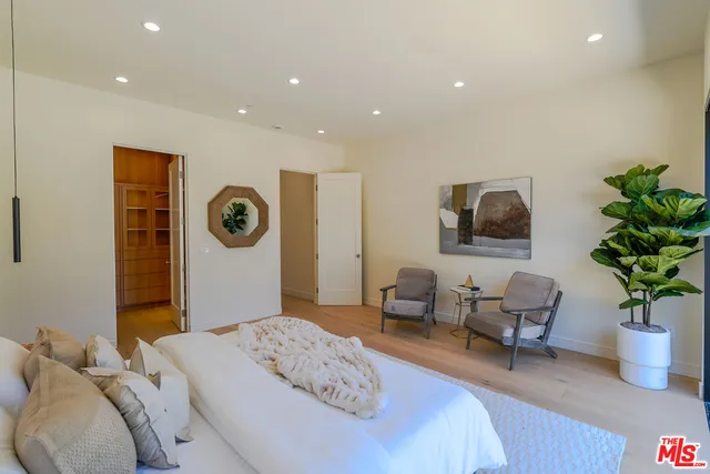 a bedroom with a bed and a potted plant