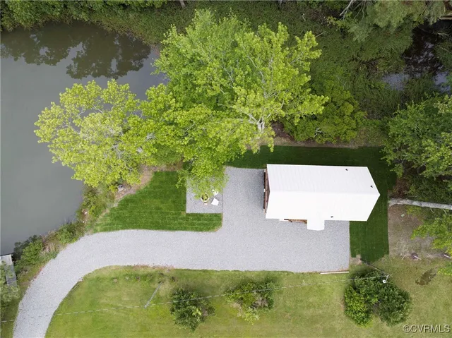 an aerial view of a house with a yard and lake view