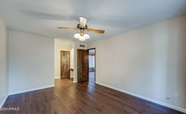 a view of an empty room with wooden floor