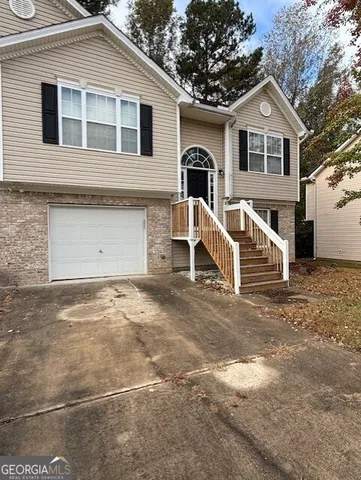 a view of a white house with a yard and large tree