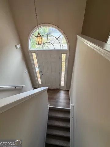 an empty room with wooden floor and staircase