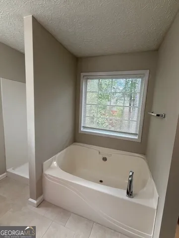 a white bath tub sitting in a bathroom next to a window
