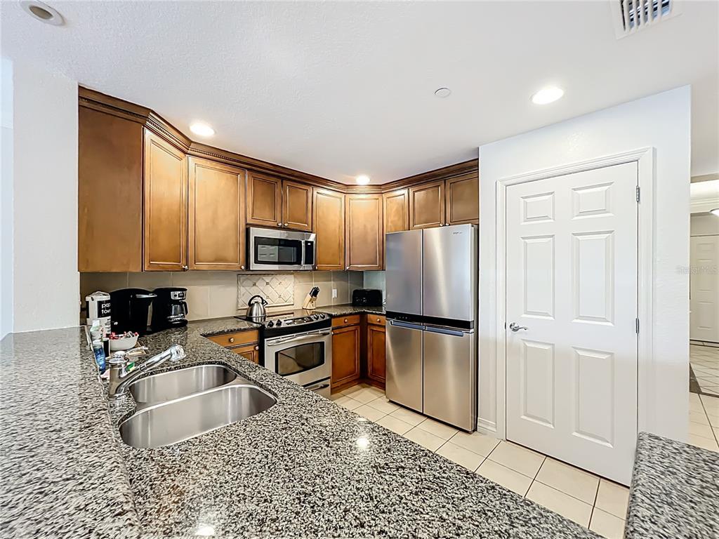 7660 Whisper Way, Unit 402 Reunion, FL 34747 - Photo 11 of 65 a kitchen with granite countertop a refrigerator and a sink