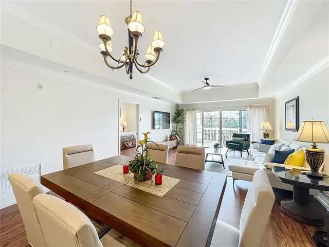 a living room with furniture large window and wooden floor