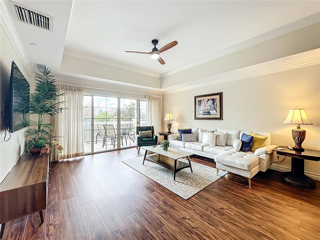 7660 Whisper Way, Unit 402 Reunion, FL 34747 - Photo 16 of 65 a living room with furniture large window and wooden floor