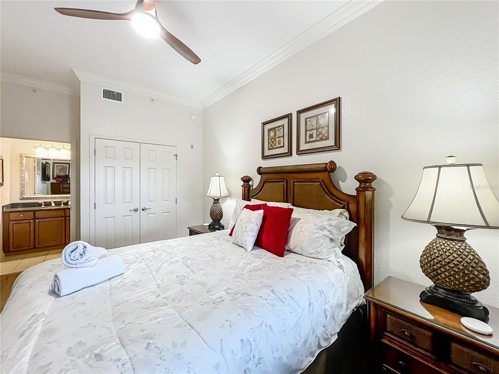 7660 Whisper Way, Unit 402 Reunion, FL 34747 - Photo 22 of 65 a bedroom with a bed and a chandelier
