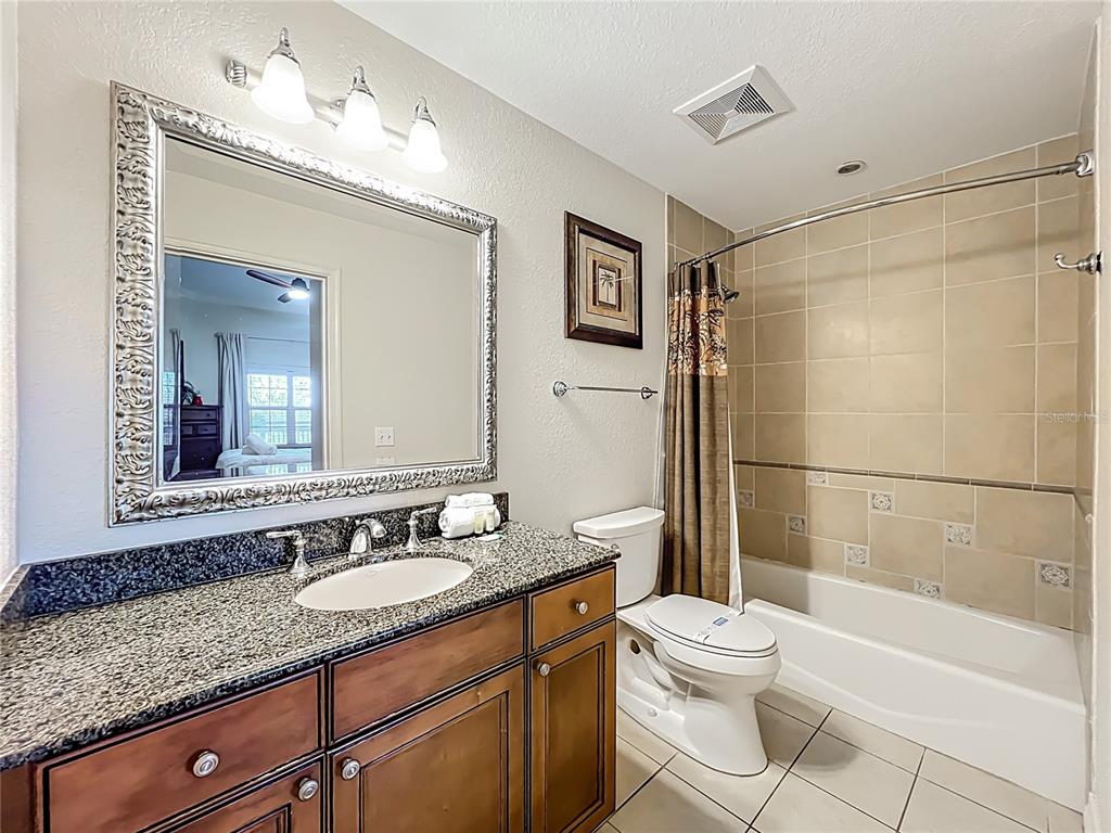 7660 Whisper Way, Unit 402 Reunion, FL 34747 - Photo 23 of 65 a bathroom with a granite countertop sink toilet and shower