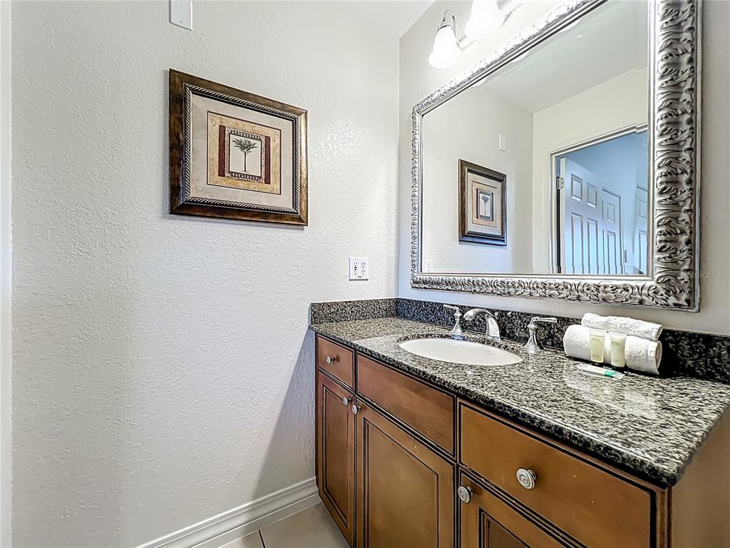 7660 Whisper Way, Unit 402 Reunion, FL 34747 - Photo 24 of 65 a bathroom with a granite countertop sink and a mirror