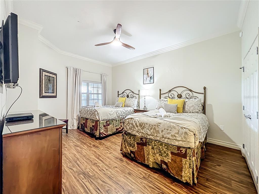 7660 Whisper Way, Unit 402 Reunion, FL 34747 - Photo 25 of 65 a bedroom with two beds and a chandelier