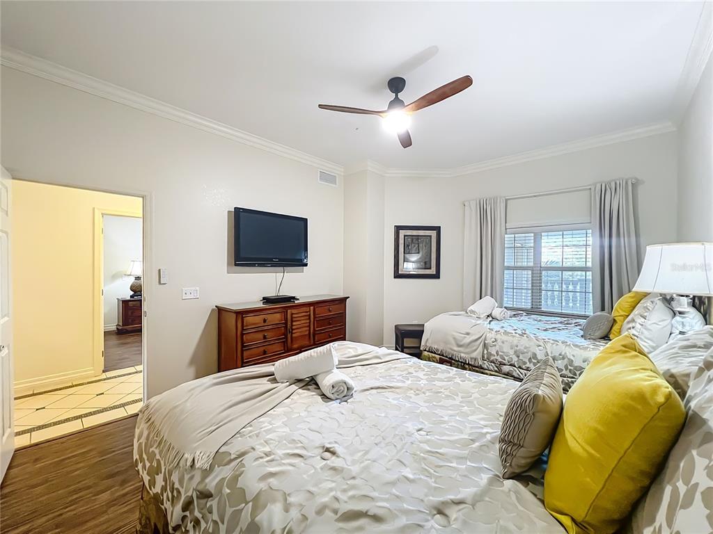 7660 Whisper Way, Unit 402 Reunion, FL 34747 - Photo 27 of 65 a bedroom with a bed and wooden floor