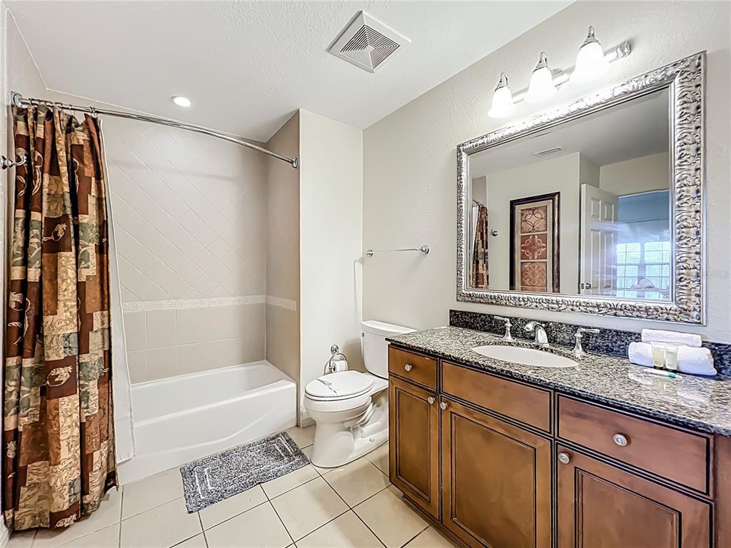 7660 Whisper Way, Unit 402 Reunion, FL 34747 - Photo 29 of 65 a bathroom with a double vanity sink toilet mirror and bathtub