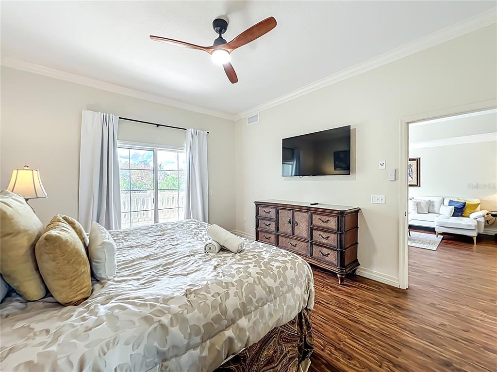 7660 Whisper Way, Unit 402 Reunion, FL 34747 - Photo 33 of 65 a bedroom with a bed a flat screen tv and dresser