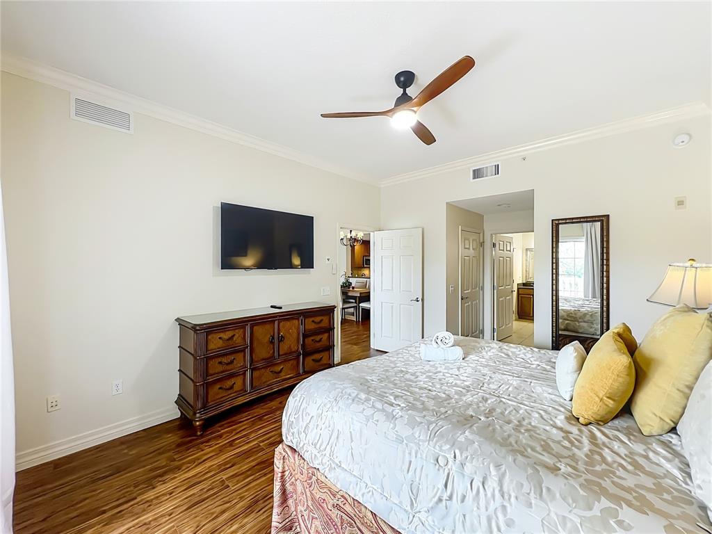 7660 Whisper Way, Unit 402 Reunion, FL 34747 - Photo 34 of 65 a bedroom with a bed and a flat screen tv